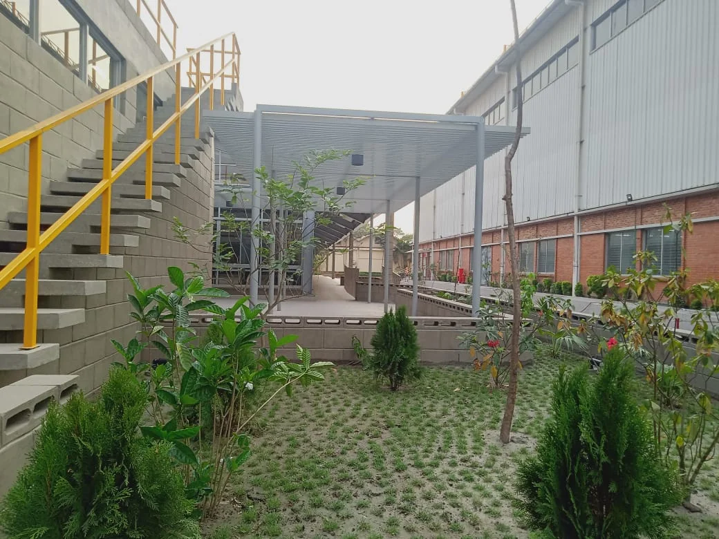 Mosque as-built: outdoor terrace with planted landscape, pergola, and stair to roof