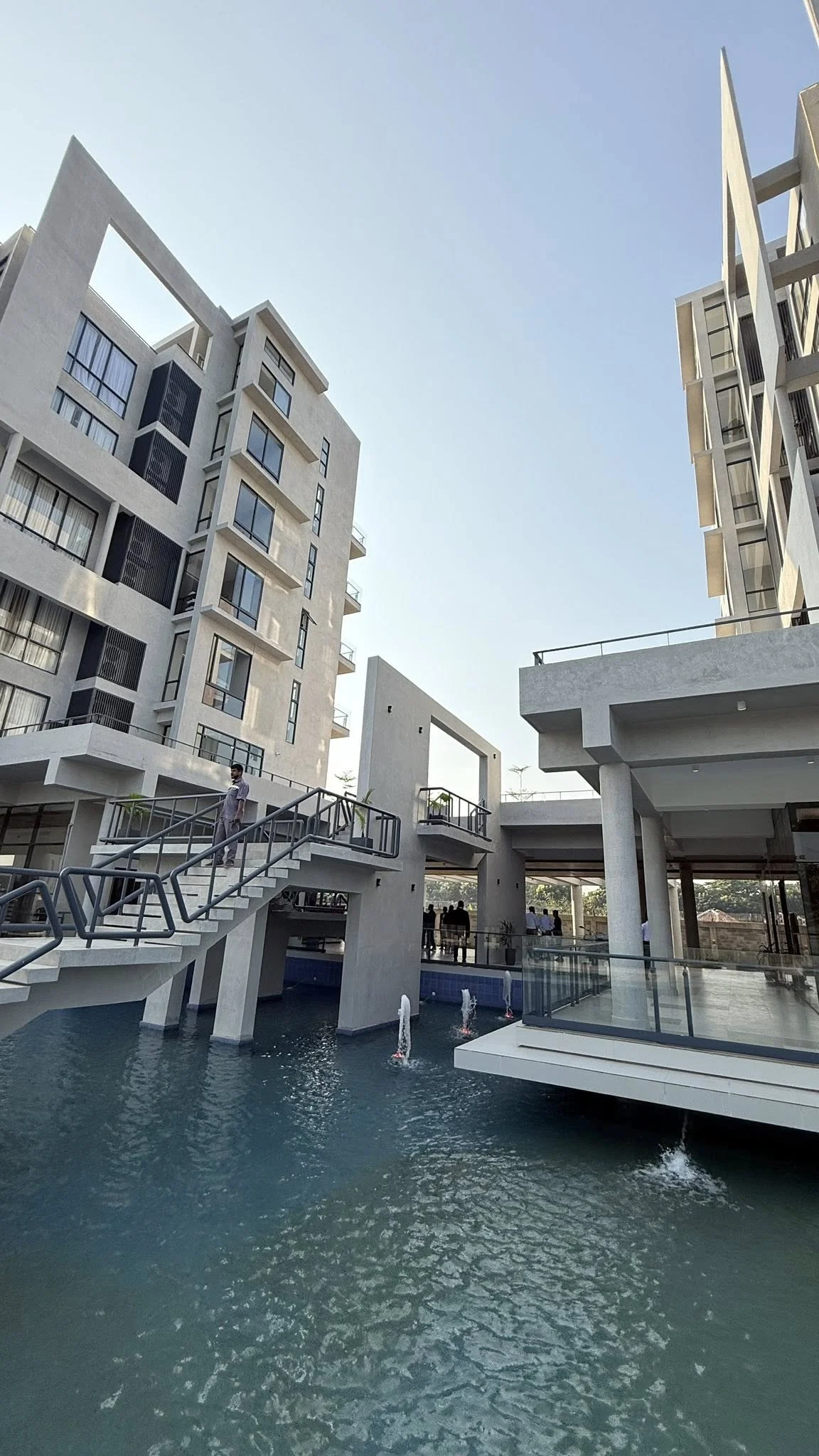 The plaza between the two accommodation blocks: reflecting pool with fountains, glass walkways and stair connections, the buildings rising on either side