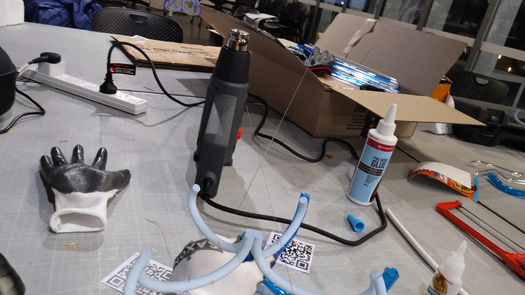 HoloLens capture: team member aligning a tube section to holographic guide, precise positioning before fixing the joint