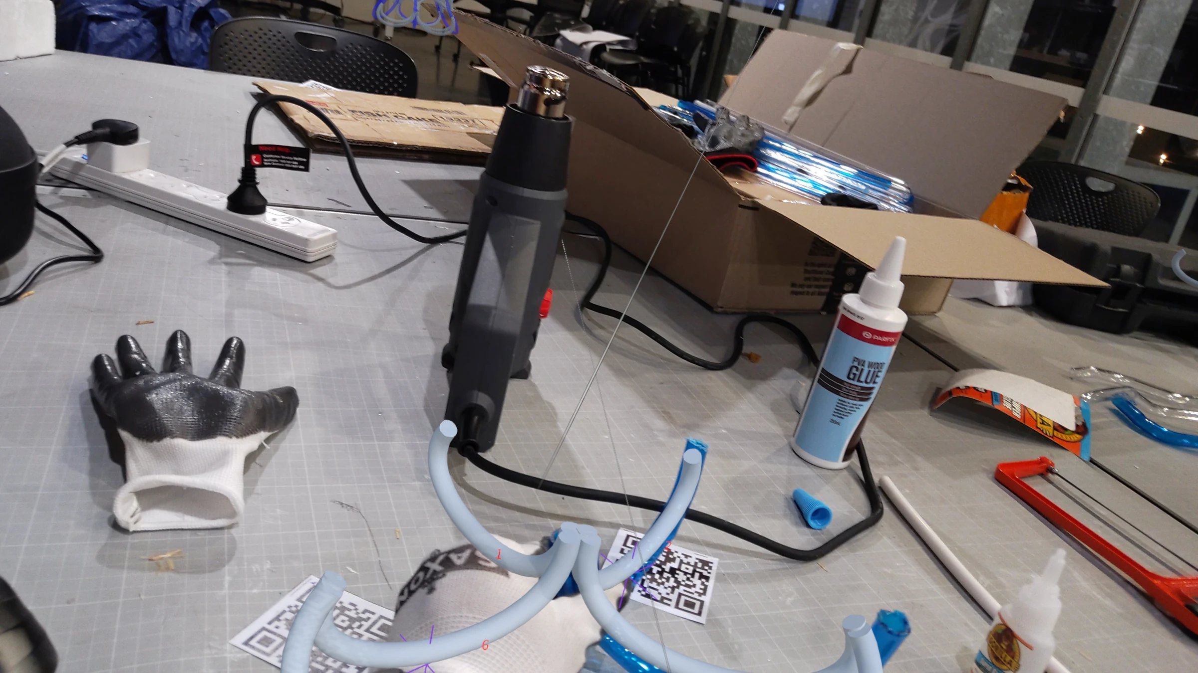 HoloLens capture: team member aligning a tube section to holographic guide, precise positioning before fixing the joint